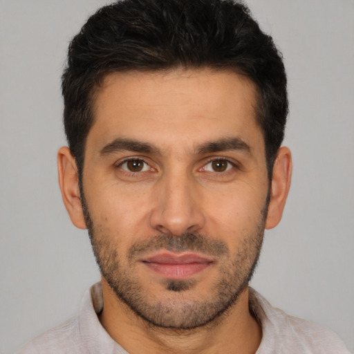 Joyful white young-adult male with short  black hair and brown eyes