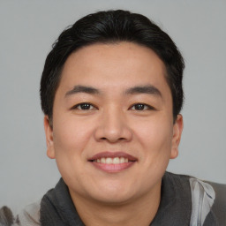 Joyful asian young-adult male with short  black hair and brown eyes