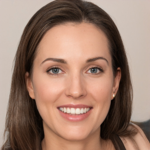 Joyful white young-adult female with long  brown hair and grey eyes