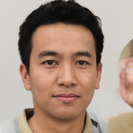 Joyful asian young-adult male with short  black hair and brown eyes