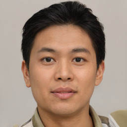 Joyful asian young-adult male with short  brown hair and brown eyes