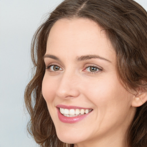 Joyful white young-adult female with long  brown hair and green eyes