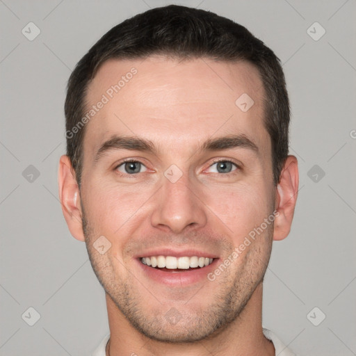 Joyful white young-adult male with short  brown hair and grey eyes