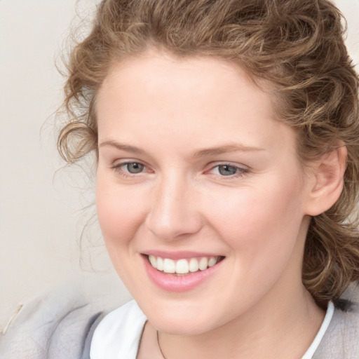 Joyful white young-adult female with medium  brown hair and blue eyes