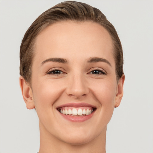 Joyful white young-adult female with short  brown hair and grey eyes