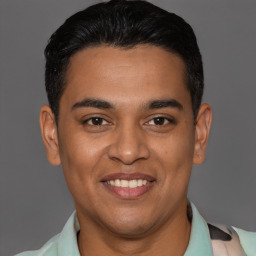 Joyful latino young-adult male with short  brown hair and brown eyes