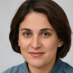 Joyful white young-adult female with medium  brown hair and green eyes