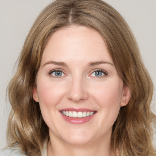 Joyful white young-adult female with medium  brown hair and green eyes