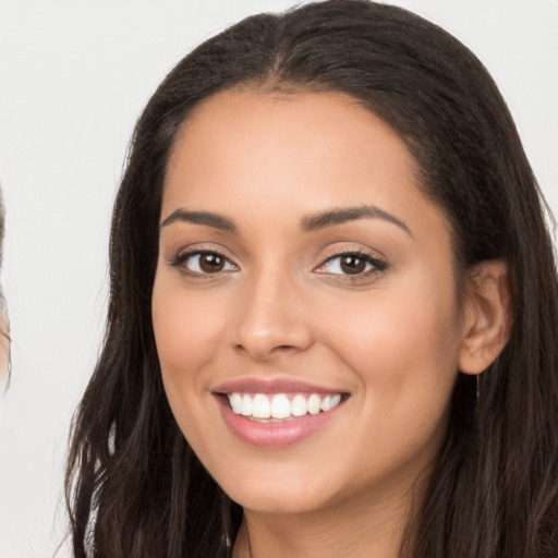 Joyful latino young-adult female with long  brown hair and brown eyes