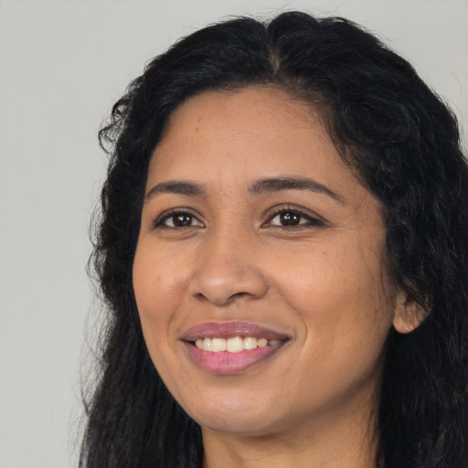 Joyful latino young-adult female with long  black hair and brown eyes