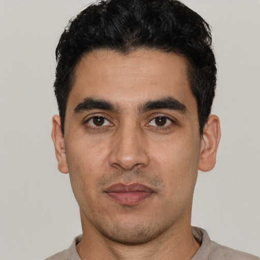 Joyful white young-adult male with short  black hair and brown eyes