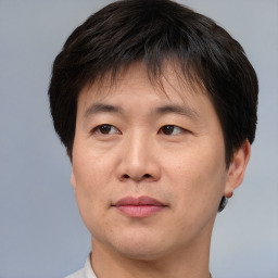 Joyful asian adult male with short  brown hair and brown eyes