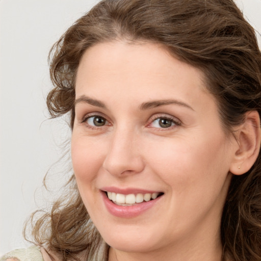 Joyful white young-adult female with medium  brown hair and green eyes