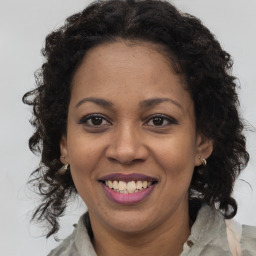 Joyful black adult female with long  brown hair and brown eyes