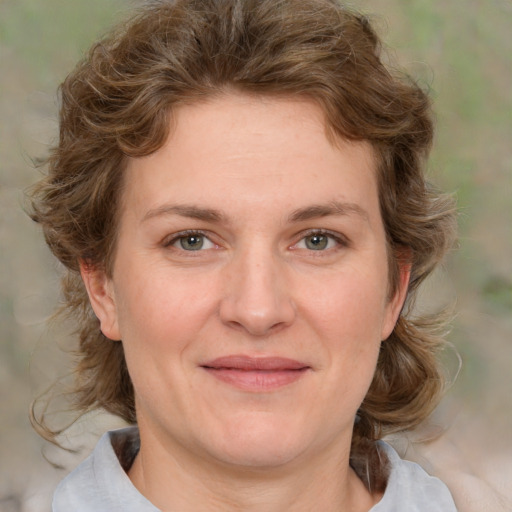 Joyful white young-adult female with medium  brown hair and green eyes