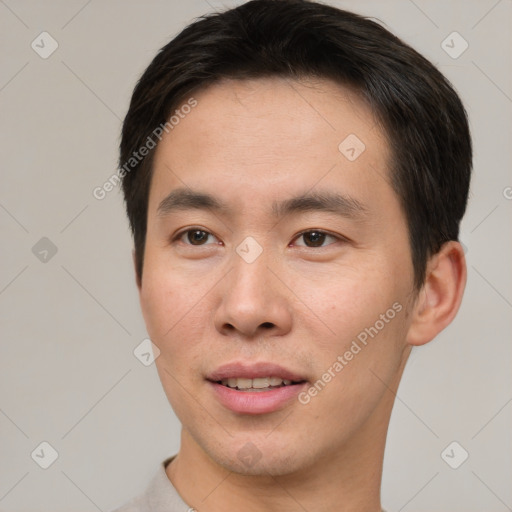 Joyful asian young-adult male with short  brown hair and brown eyes