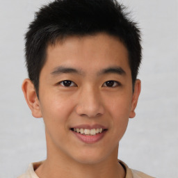 Joyful asian young-adult male with short  brown hair and brown eyes