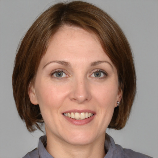 Joyful white adult female with medium  brown hair and blue eyes