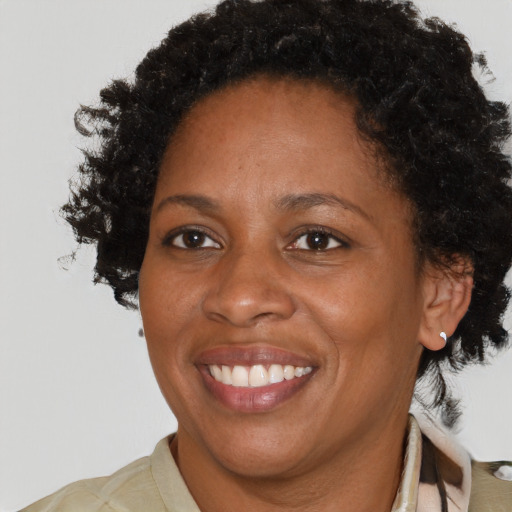Joyful black adult female with medium  brown hair and brown eyes