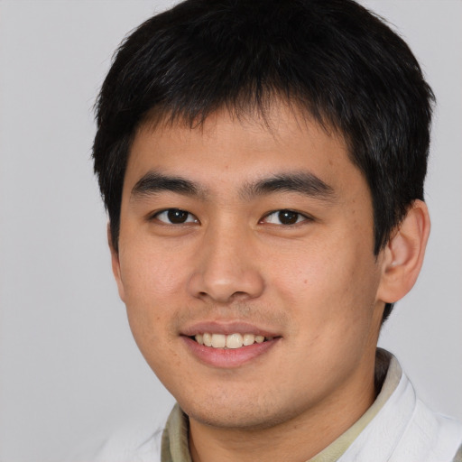 Joyful asian young-adult male with short  brown hair and brown eyes