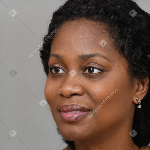 Joyful black young-adult female with long  black hair and brown eyes