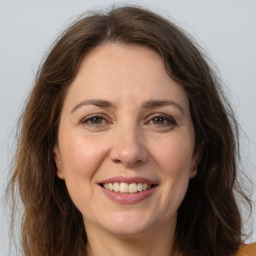 Joyful white adult female with long  brown hair and grey eyes