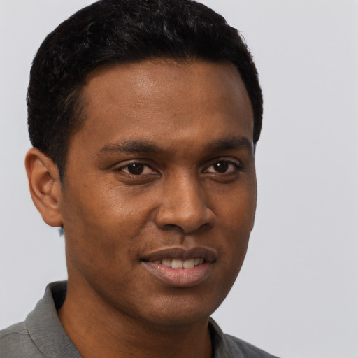 Joyful black young-adult male with short  brown hair and brown eyes