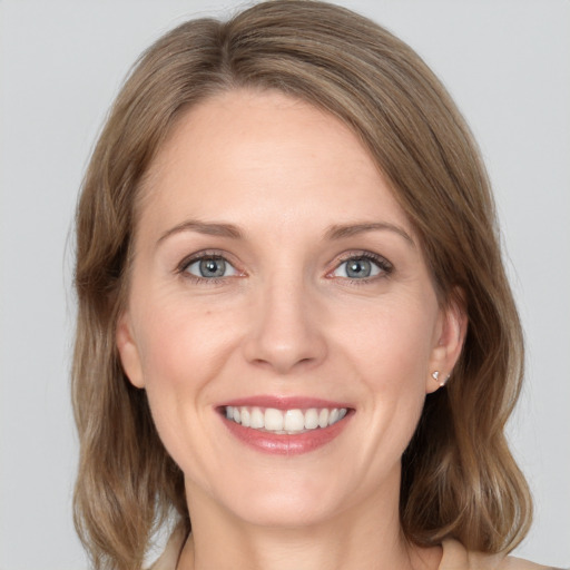 Joyful white adult female with medium  brown hair and grey eyes