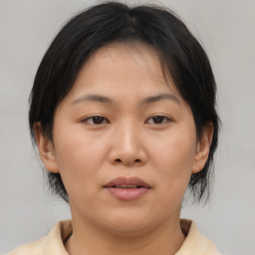 Joyful asian young-adult female with medium  brown hair and brown eyes