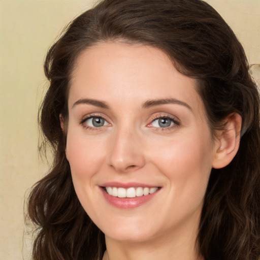 Joyful white young-adult female with long  brown hair and green eyes