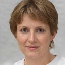 Joyful white adult female with medium  brown hair and grey eyes