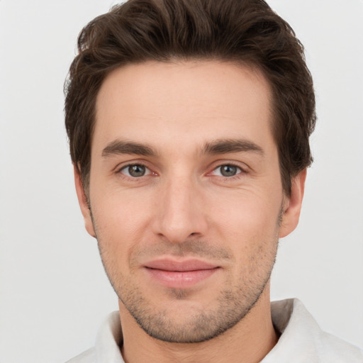 Joyful white young-adult male with short  brown hair and grey eyes