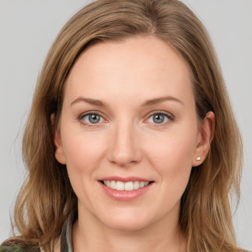 Joyful white young-adult female with long  brown hair and green eyes