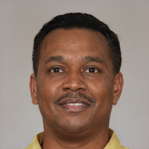 Joyful black adult male with short  brown hair and brown eyes