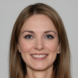 Joyful white young-adult female with long  brown hair and grey eyes