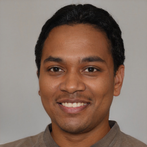 Joyful black young-adult male with short  black hair and brown eyes