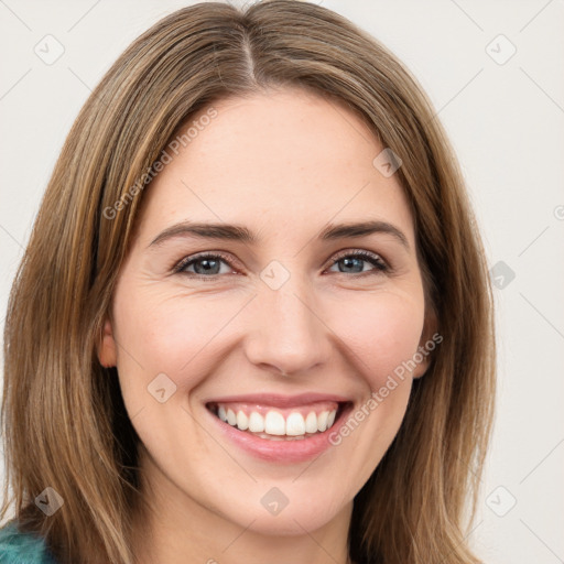 Joyful white young-adult female with long  brown hair and green eyes