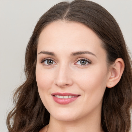 Joyful white young-adult female with long  brown hair and blue eyes