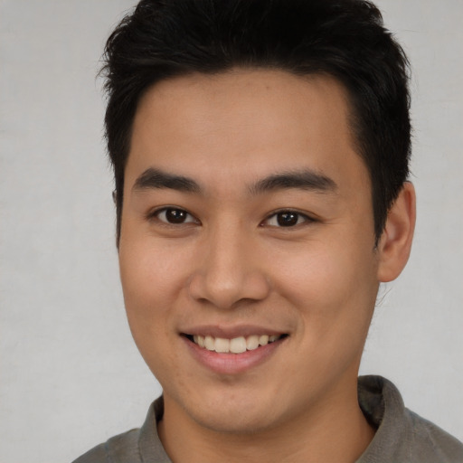 Joyful asian young-adult male with short  brown hair and brown eyes