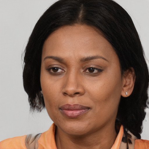 Joyful latino adult female with medium  brown hair and brown eyes