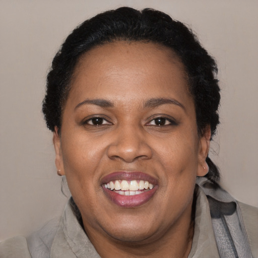 Joyful black adult female with short  black hair and brown eyes
