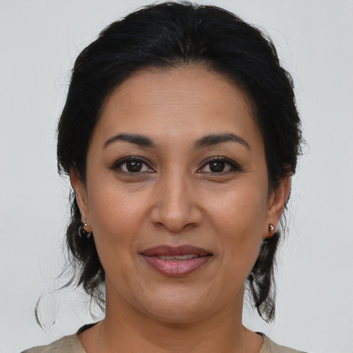 Joyful latino adult female with medium  brown hair and brown eyes