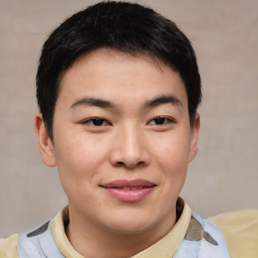 Joyful asian young-adult male with short  brown hair and brown eyes