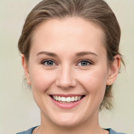 Joyful white young-adult female with medium  brown hair and grey eyes