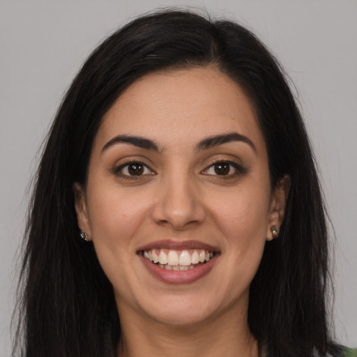 Joyful latino young-adult female with long  brown hair and brown eyes