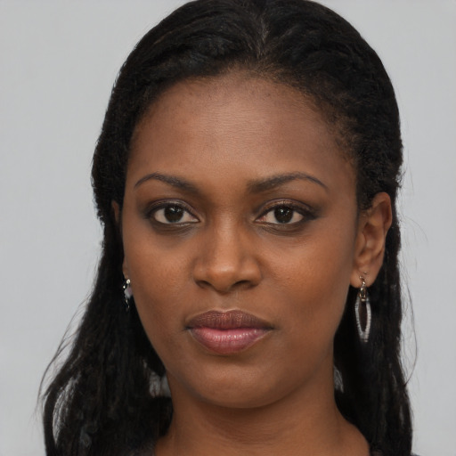 Joyful black young-adult female with long  brown hair and brown eyes