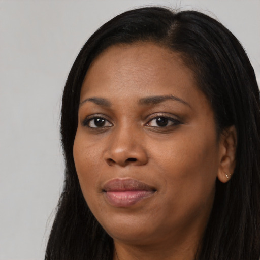 Joyful black young-adult female with long  black hair and brown eyes