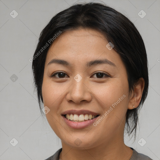 Joyful asian young-adult female with medium  brown hair and brown eyes