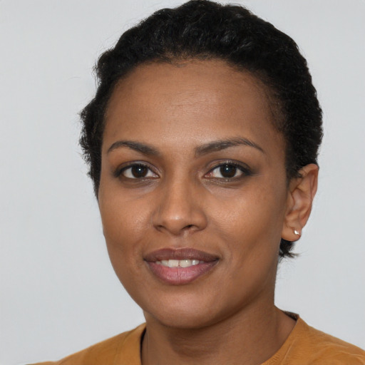 Joyful black young-adult female with short  brown hair and brown eyes