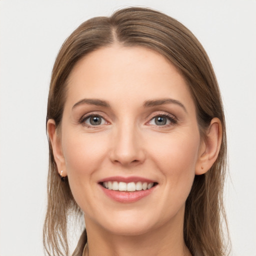 Joyful white young-adult female with long  brown hair and grey eyes